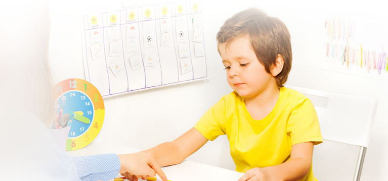 Boy putting colorful shaped coins