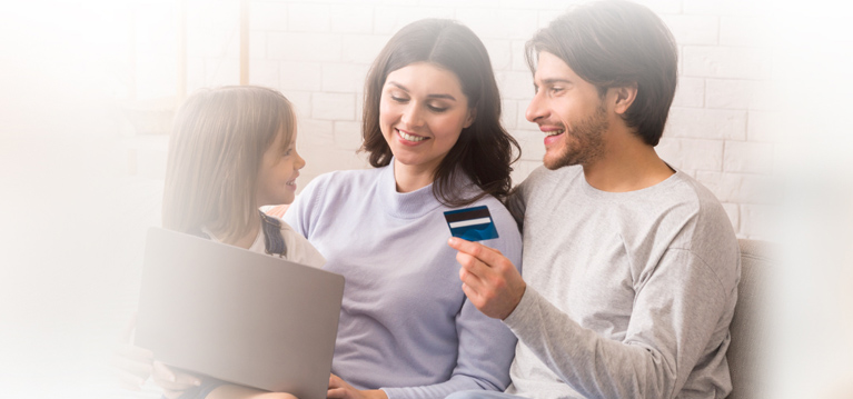 Modern Family With Little Daughter Using Laptop Computer And Credit Card