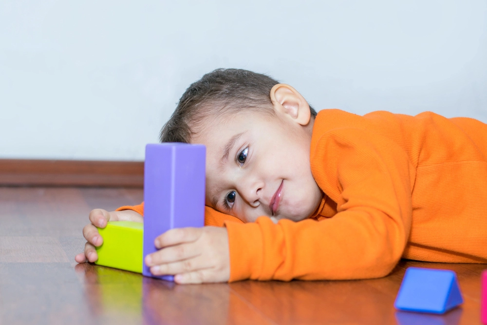 Child Engaged with Colorful Building Blocks on the Floor