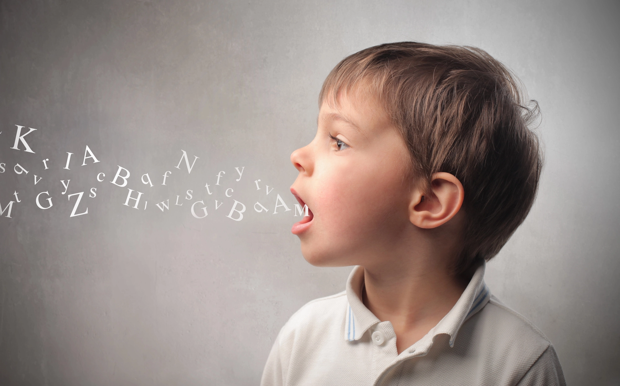 Young boy speaking with letters flowing out of his mouth.